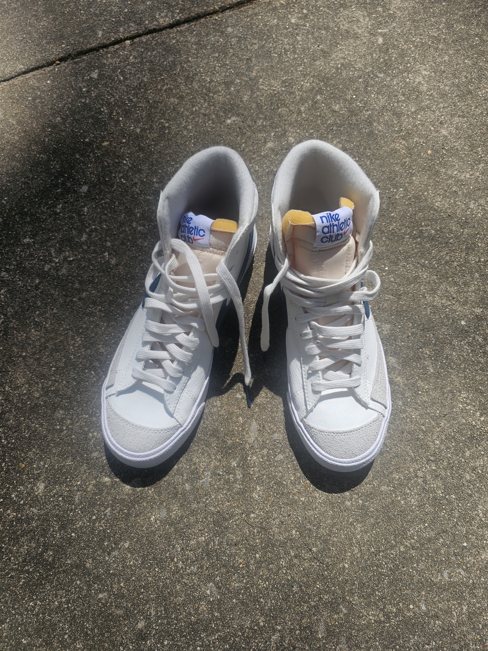 Nike White High-Top Sneakers with Navy Logo and Yellow Tongue Accent